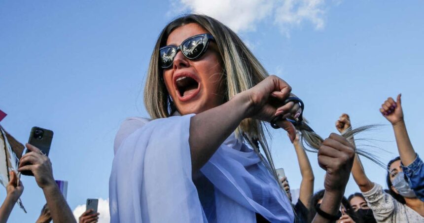 Une femme se coupe les cheveux lors d'une manifestation à Istanbul, le 2 octobre 2022 © Dilara Senkaya